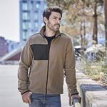 Mountain Fleece Herren Outdoorjacke in Braun mit schwarzem Brustbereich, getragen von Model in urbaner Umgebung