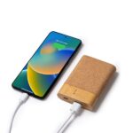 Nachhaltige Powerbank mit Korkoberfläche und Bambusbasis, per USB-Kabel mit einem Smartphone verbunden und im Ladevorgang