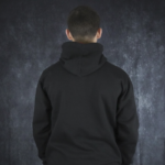 Back view of a person wearing a black Meenzer Fastnachtshoodie with the hood up.