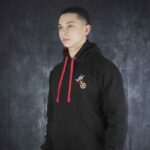 Person wearing the Meenzer Fastnachtshoodie with red drawstrings and embroidered jester hat above a Mainz wheel symbol