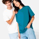 Umweltfreundliches Unisex-T-Shirt mit hängenden Schultern – Modell trägt lockeres French Terry Shirt in Weiß und Türkis, ideal für Alltag oder Freizeitmode