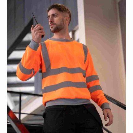 Mann mit leuchtend orangefarbenem Hi-Vis Sweatshirt „Limerick“ mit reflektierenden Streifen, ideal für Arbeitskleidung